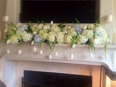 a fireplace decorated with flowers and candles