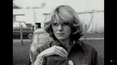 an old black and white photo of a woman holding a hot dog in her hand