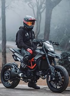 a man riding on the back of a motorcycle down a road in front of trees