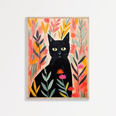 a black cat with yellow eyes sitting in front of flowers and leaves on a white wall