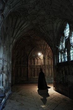 a person in a dark room with light shining through the windows