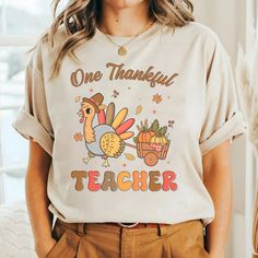 Thanksgiving Teacher Shirts, Fall Teacher Shirts, Teacher Tshirt, Teacher Fall Shirt, One Thankful Teacher Tees, Cute Teacher T Shirt We've got all this and more: - Tshirt material: cotton, polyester - Sweatshirt material: cotton, polyester - Hoodie material: fleece fabric, heavy blend Production and Shipping - Processing Time: 3-5 business days - Shipping time (US): 3-5 business days - Shipping time (WW): 10-15 business days Note - Manual measurement may exist a 1-2cm difference - Actual colors may be slightly different from the image due to different monitor and light effects. - Please contact our support team for detailed information. - No returns or exchanges unless there's a defect or our mistake Thank you for choosing my store! Funny Cotton Tops For Fall, Thanksgiving Teacher Shirts, Fall Teacher Shirts, Teacher Tees, Teacher Christmas, Hoodie Material, Fall Shirt, Teacher Tshirts, Fall Shirts