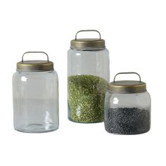 three glass jars with metal lids are shown on a white background, one is empty and the other has seeds in it