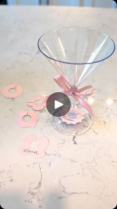 a glass bowl with a pink bow on it sitting on top of a white table