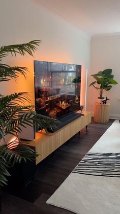 a large flat screen tv sitting on top of a wooden entertainment center in a living room