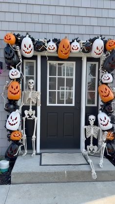 a front door decorated for halloween with skeletons and pumpkins