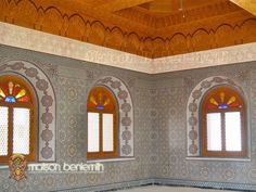 an ornate room with three windows and tiled walls