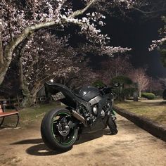 a black motorcycle parked next to a park bench