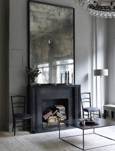 a living room filled with furniture and a large mirror on the wall over a fire place