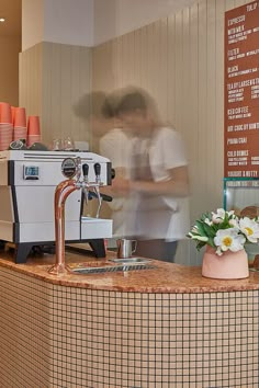 a person standing behind a counter in a coffee shop