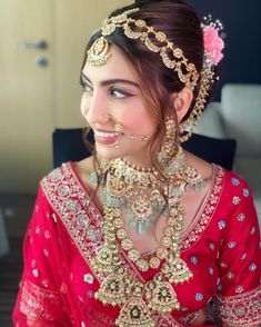 a woman wearing a red and gold bridal outfit