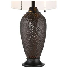 a table lamp with a white shade on the base and a brown vase shaped like an egg