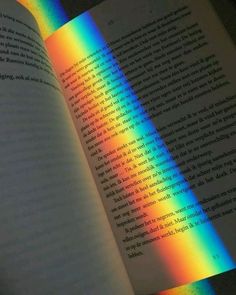 an open book with rainbow light coming from it