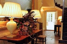 a table with two lamps on top of it next to a stair case and mirror