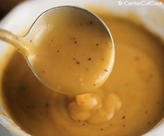 a ladle full of soup being held by a spoon