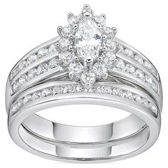 a wedding ring set with an oval cut diamond and round diamonds on the band, in white