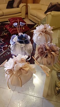 three small bags with flowers on them sitting on a table in front of couches