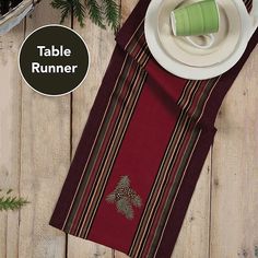 the table runner is next to a white plate and silverware on a wooden table