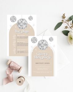 the wedding stationery is laid out on top of some paper and ribbon, along with other items