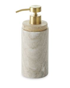 a white marble soap dispenser with gold accents