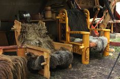 an old wooden chair with sheep furs on it and other items in the background