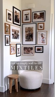 a white chair sitting in front of a wall filled with pictures