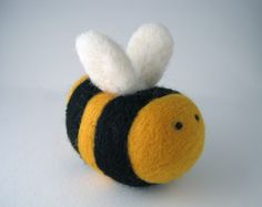 a needle - felted bee ornament is shown on a white surface