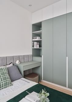 a bedroom with white walls and green carpeted flooring, built - in bookshelves