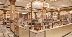 the interior of a store with many items on display in glass cases and chandeliers