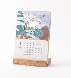 a desk calendar sitting on top of a wooden stand in front of a white background