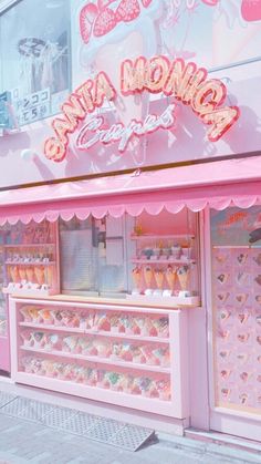 a pink and white store front with lots of cupcakes