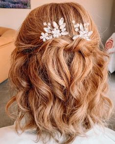 a close up of a woman's hair with flowers in the top half of her head