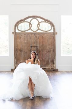 a woman in a wedding dress sitting on the floor