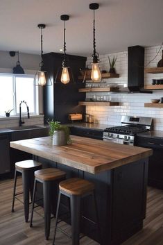 a kitchen with black cabinets and wooden counter tops, two stools at the island