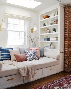 a living room filled with lots of furniture and bookshelves next to a window