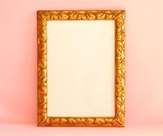 a gold frame on a pink wall with an empty space in the middle for text