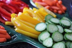 several different types of vegetables are arranged on trays with spoons in the foreground