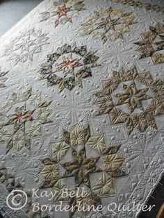 a quilted table topper with many different designs on it