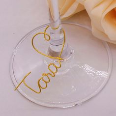 a wine glass with the word love written on it and a rose in the background