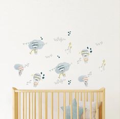 a baby's crib in front of a wall with hot air balloons on it