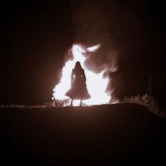 a person standing in front of a fire