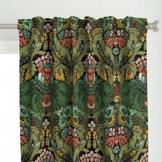 a green curtain with colorful flowers and leaves on it