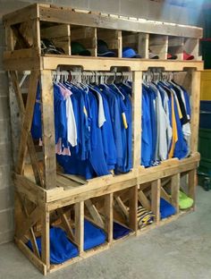 a wooden rack filled with lots of blue shirts