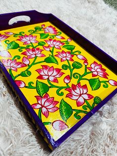 a colorful tray with flowers painted on it sitting on a white furnishing area