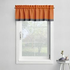 a window with an orange polka dot valance