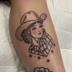 a woman with a cowboy hat on her leg is shown in black and grey ink