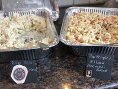 two pans filled with macaroni and cheese sitting on top of a counter