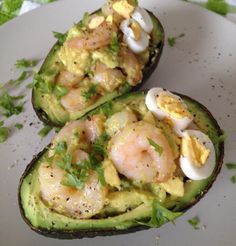 two halves of avocado with shrimp and eggs