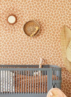 a giraffe print wallpaper in a baby's room with a crib