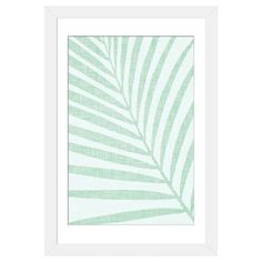 a green and white palm leaf print in a white frame on a white wallpaper